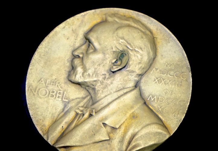 Ett stort gyldmynt med en avbildning av Alfred Nobel.