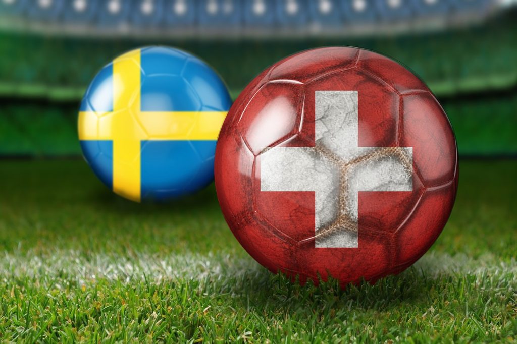 två fotbollar en med sveriges flagga och en med schweiz