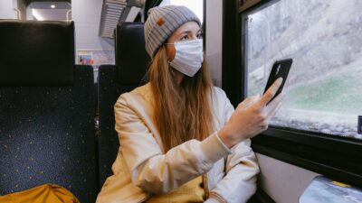Tjej på tåg med munskydd